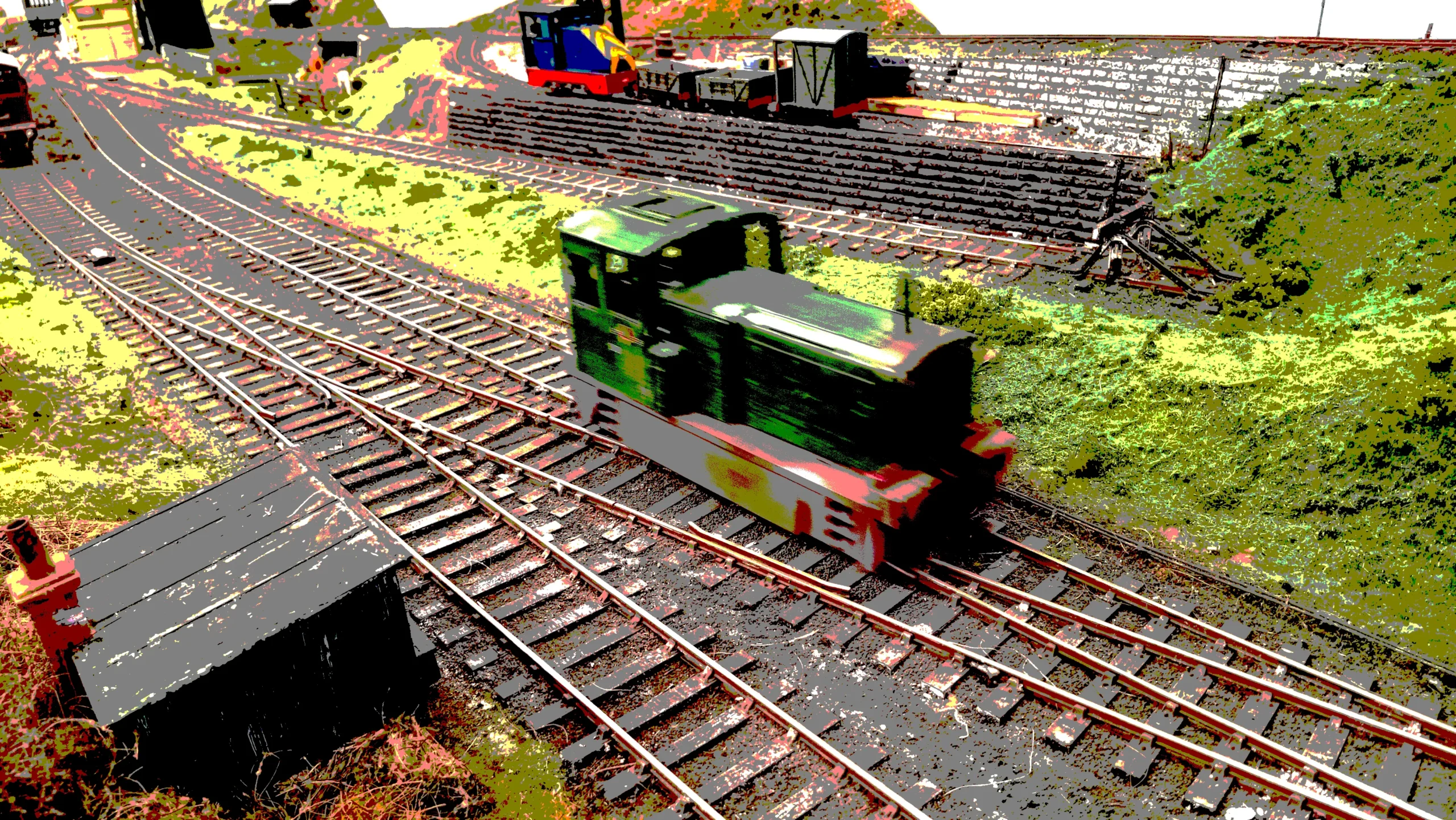 a diesel locomotive on a o scale model railway going down the line.